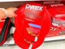 hand grabbing a pyrex glass mixing bowl set off a target shelf