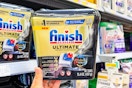 hand holding a container of Finish Dishwasher pods