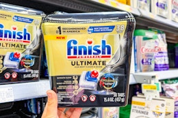 hand holding a container of Finish Dishwasher pods