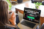 a woman holding a cup of coffee with a laptop displaying the offer for 30 days free with ads on Hulu