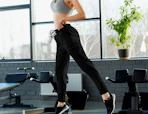a woman in the gym wearing black joggers
