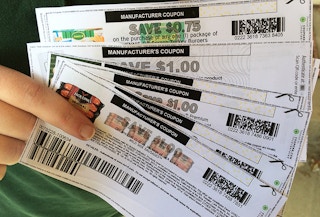 A person holding coupons for meat.