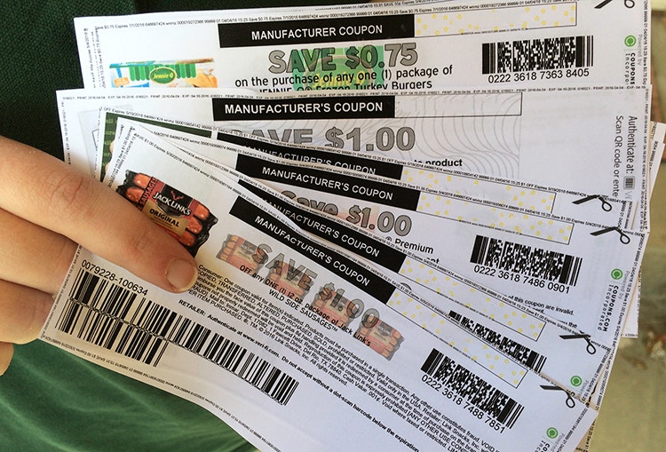 A person holding coupons for meat.