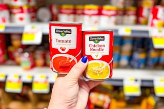 hand holding up two cans of clover valley soup