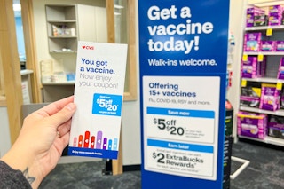 hand holding a coupon flyer for $5 off your $20 purchase with vaccination at CVS pharmacy