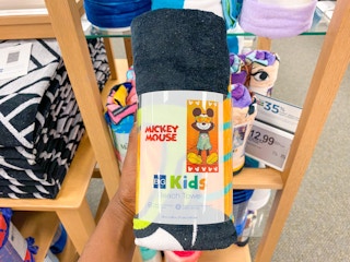 someone holding disney beach towels