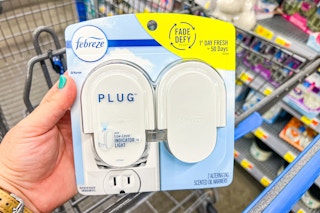 hand holding febreze plug scented oil warmer over Walmart shopping cart