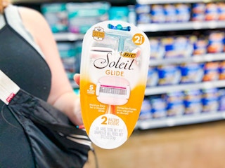 woman holding a pack of bic soleil 5 glide razors in walmart aisle