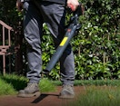 a person holding a leaf blower outside