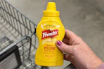 hand holding a bottle of frenchs mustard