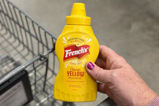 hand holding a bottle of frenchs mustard