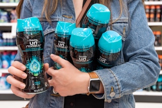 person holding five bottles of Downy Unstopables in arms