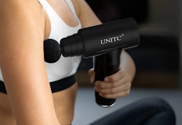 person using the mini massage gun on their arm