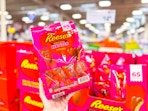 hand holding a bag of reeses hearts