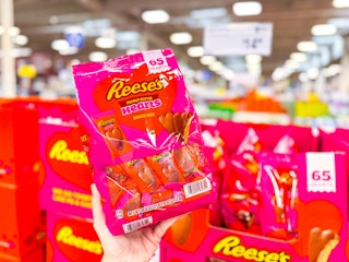 hand holding a bag of reeses hearts