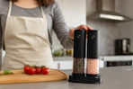 a woman holding a salt and pepper grinder