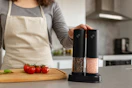 a woman holding a salt and pepper grinder