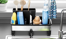 a sink caddy on a sink with sponges, brushes, and dish soap