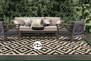 A reversible waterproof outdoor rug with a geometric beige and black diamond pattern