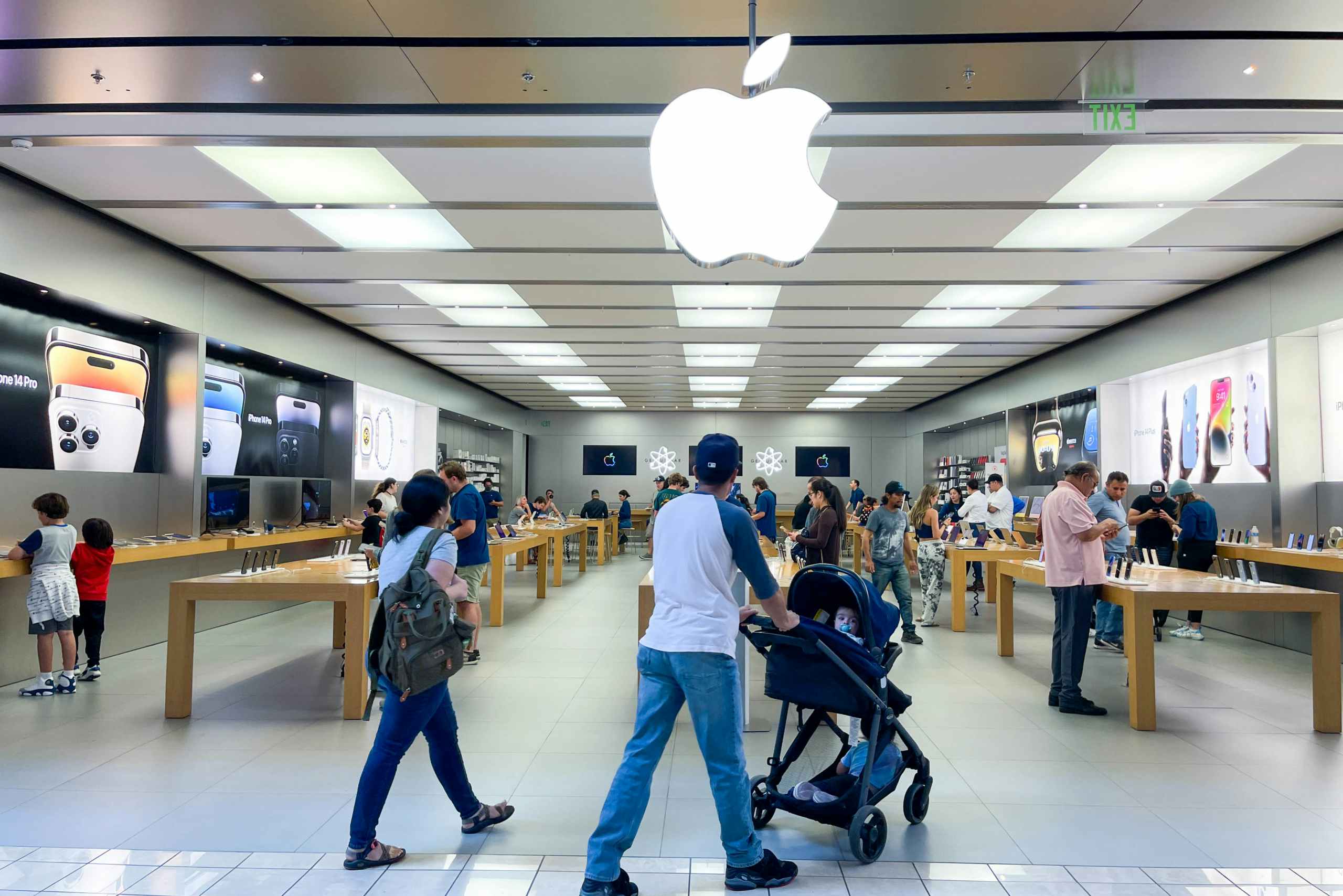 a couple walking into a busy apple store