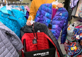 A person shopping for kids puffer coats at Kohl's
