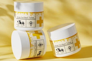 Three jars of beef tallow and honey moisturizer with yellow and gold labels in front of a beige background