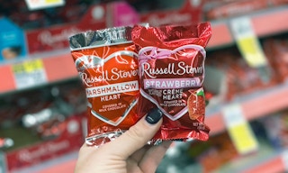 hand holding two Russell Stover heart chocolates