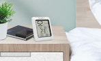 an indoor thermometer/hygrometer on a nightstand 