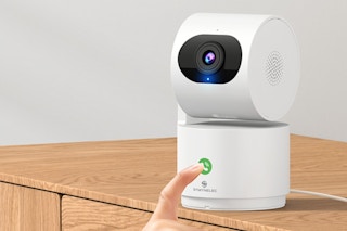 a hand touching a 2k indoor camera