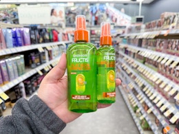 hand holding garnier fructis styling products in walgreens