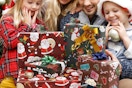 a family looking at christmas presents wrapped with christmas wrapping paper sheets