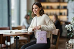 Women in a restaurant setting wearing a purple MK Collection purse