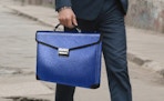 a person carrying a blue document bag 