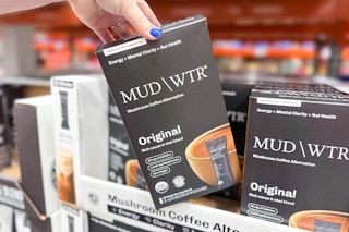 hand picking up a box of mud/wtr mushroom coffee alternative