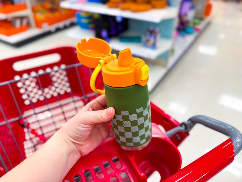 hand holding an opened cat & jack water bottle over target cart