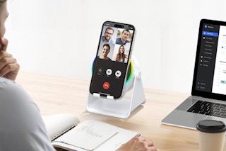 Man using the GIM Wireless Induction Speaker, 4 in 1 Bluetooth Speaker Phone Stand while working.