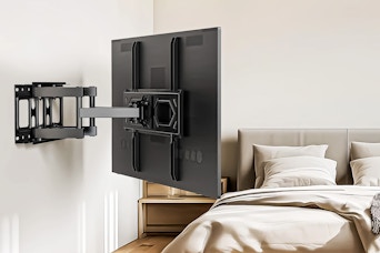 Lifestyle image of a TV mounted on the wall at a swivel toward bed