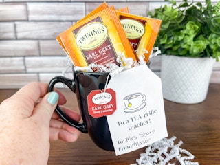 a person holding a tea time teacher gift 