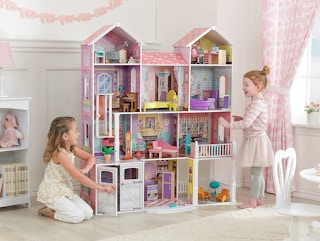 Two children playing with a KidKraft Country Estate Dollhouse