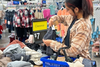 Woman looking at kids clothing on clearance in walmart