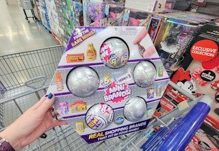 hand holding a 5-pack of zuru surprise mini brand toys