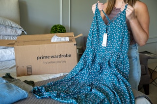 A woman holding up a Blue Roxy dress.