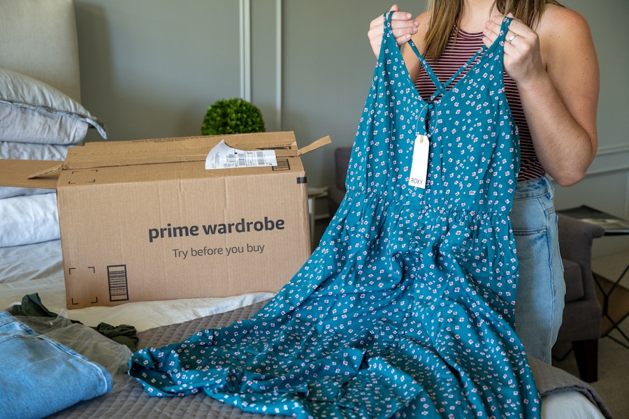 A woman holding up a Blue Roxy dress.