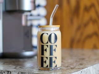 a coffee cup filled with iced coffee sitting in front of a keurig