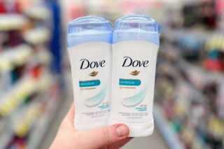 a hand holding two sticks of deodorant