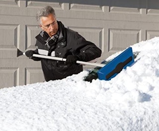 A man scrapping snow off of a car