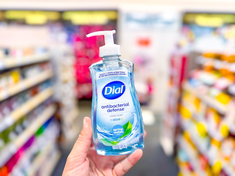 person holding a dial hand soap in an aisle