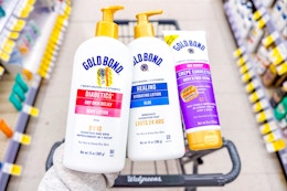 hand holding three gold bond lotions