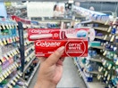 hand holding colgate toothbrush and toothpaste in walgreens