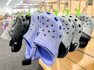 glitter crocs hanging in display purple and grey